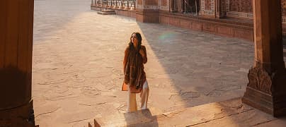 A woman explores an Indian temple at sunset